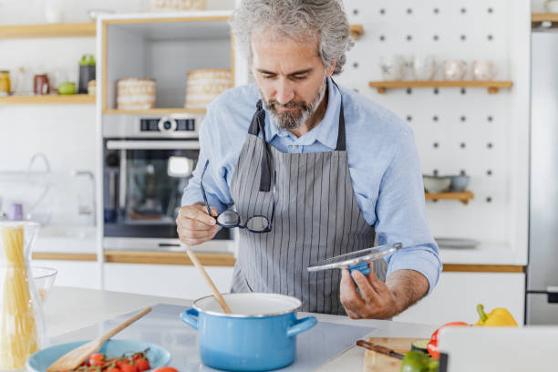 istock Senior man preparing meal at home 1335964529