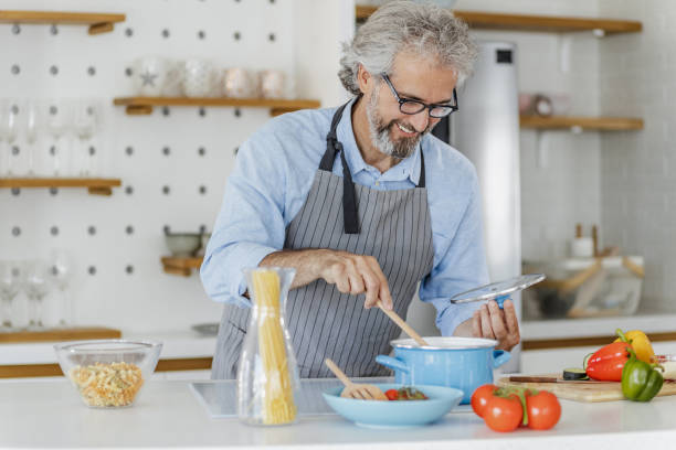istock Senior man preparing meal at home 1335964590