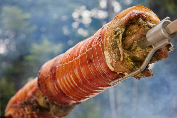 rolled pork loin roast on an outdoor spit - roasted spit roasted roast pork barbecue grill imagens e fotografias de stock