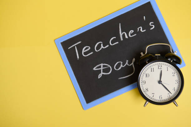 istock Flat lay composition from an alarm clock and chalkboard on yellow background with space for text. Teacher's Day 1335969808