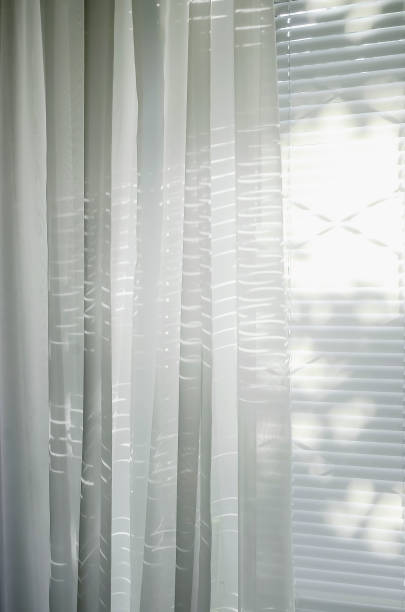 istock Sheer white organza curtain on the window, letting in sunlight. 1335969906
