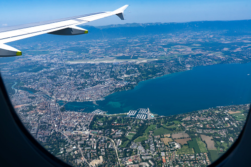 View from a plane window on aerial of Geneva and Lac Léman or Lake Geneva that is located between France and Switzerland and overlooking Alps