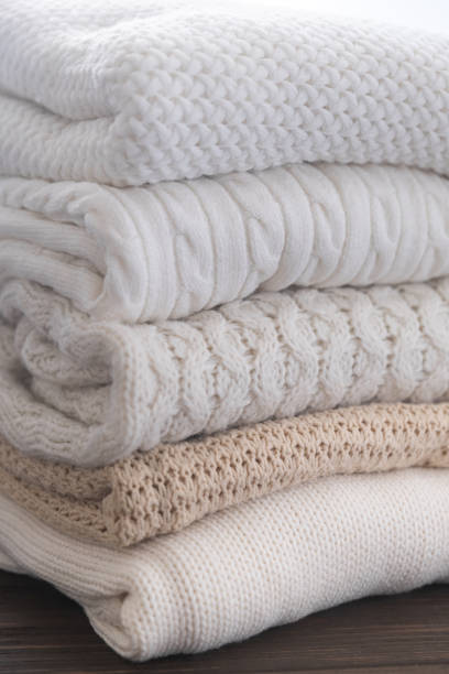 istock White and beige sweaters are stacked. Different knitted patterns. Autumn or winter background. 1335971298