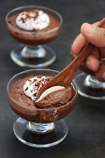 Stock photo showing a studio shot of three glasses containing a chocolate mousse dessert.
