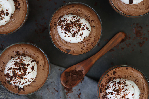 Stock photo showing a studio shot of three glasses containing a chocolate mousse dessert.