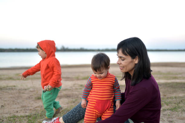 istock mother with children playing on the beach 1335976998