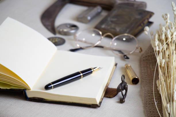 istock notebook, pen and vintage accessories on the table 1335977990