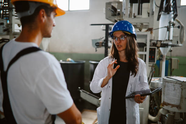 istock Female technician discussing work at the plastic up-cycling facility 1335984865