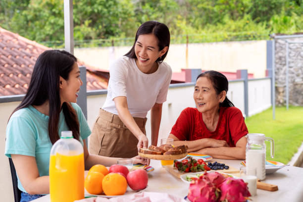 istock Smiling woman serving breakfast for family 1335984970