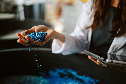 Woman technician inspecting pellets made of biodegradable materials