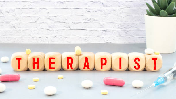 istock On the table is a stethoscope, notepad, magnifying glass and Jenga with the inscription - THERAPIST. 1335987475