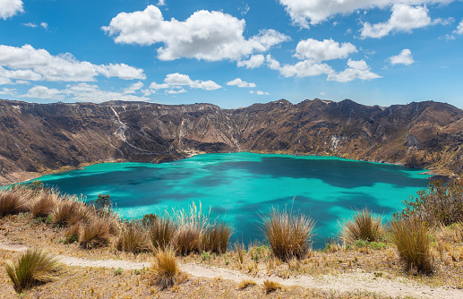Quilotoa volcanic crater lagoon with turquoise waters and Quilotoa Loop hike path near Quito, Ecuador.