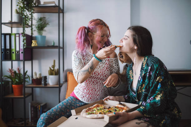 istock Lesbian couple having pizza, feeding each other 1335994331
