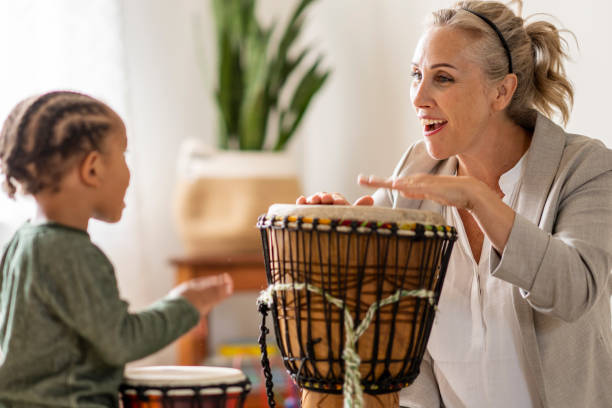 istock Female therapist using musical instruments with a child patient during play exercise 1335994500