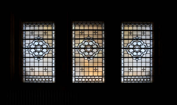 istock Simple patterned antique stained glass window silhouettes frame on black background in The national gallery. 1335994728