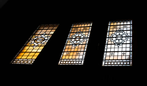 istock Simple patterned antique stained glass window silhouettes frame on black background in The national gallery. 1335994733