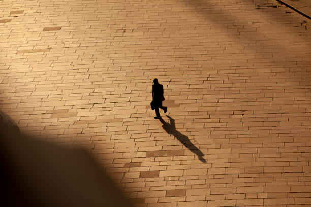 Blind person walking with white cane in urban environment, demonstrating independent mobility and navigating obstacles