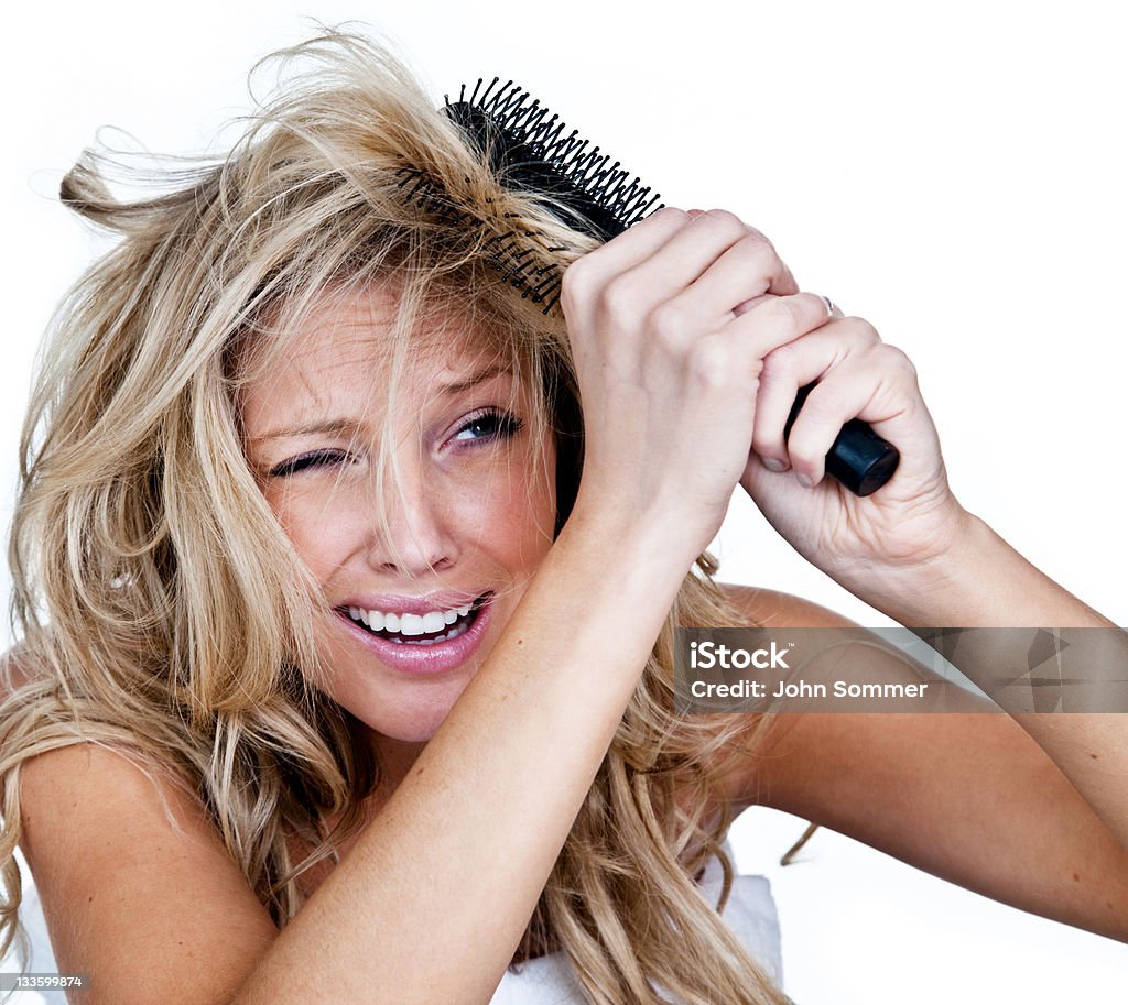 Woman having a bad hair day Woman with a brush stuck in her hair and a negative expression on her face  Frizzy Hair Stock Photo