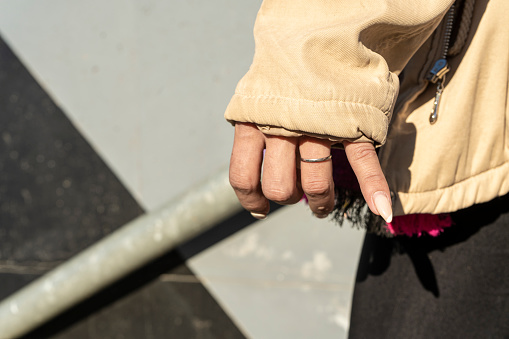 hands of a woman with painted nails taking a railing of a staircase