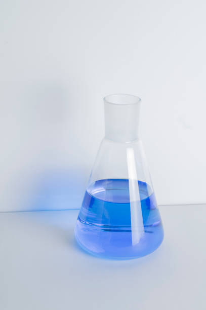 istock Laboratory glass Erlenmeyer conical flask filled with blue chemical liquid for a chemistry experiment in a science research lab,COPY SPACE 1336005387