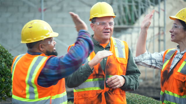 Three multi-ethnic construction workers, high-fives