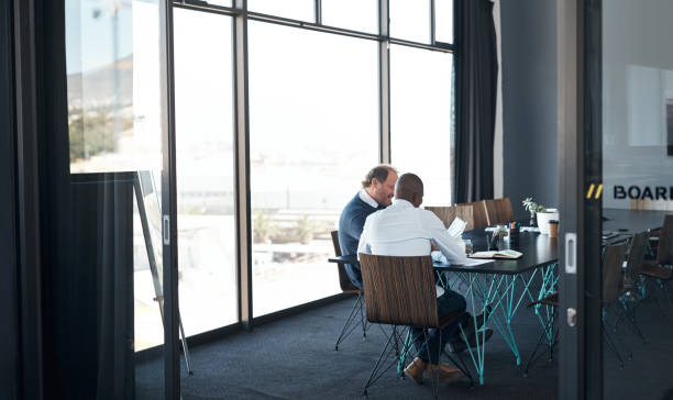 istock Shot of two businessmen going over paperwork in a modern office 1336009396