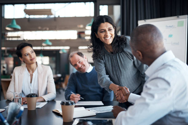 ujęcie bizneswoman i biznesmena ściskających dłonie podczas spotkania w nowoczesnym biurze - seminar women recruitment meeting zdjęcia i obrazy z banku zdjęć