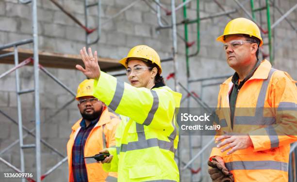 Hispanic Woman Leads Crew At Building Construction Site Stock Photo - Download Image Now