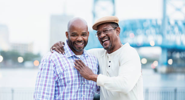 istock Senior man laughing with son, posing on city waterfront 1336010263