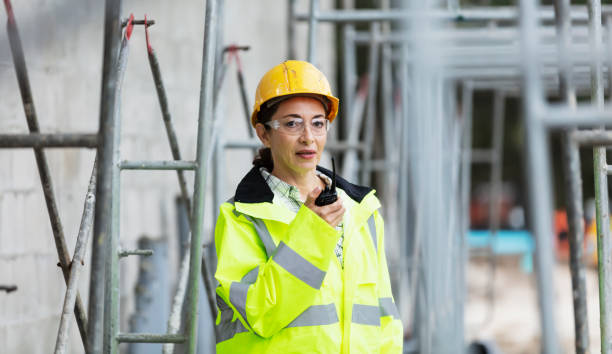 istock Hispanic woman at construction site on walkie-talkie 1336010327