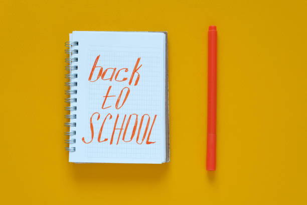 istock Flat lay. Yellow background. In the center is a notebook with the text 