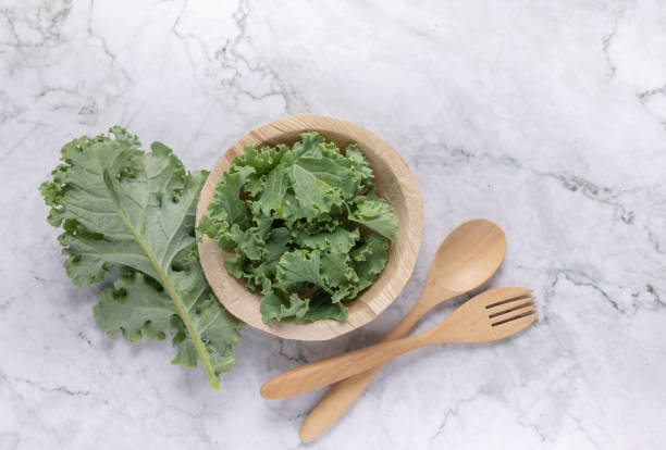 istock Fresh organic green kale leaves pattern on a white background 1336011604