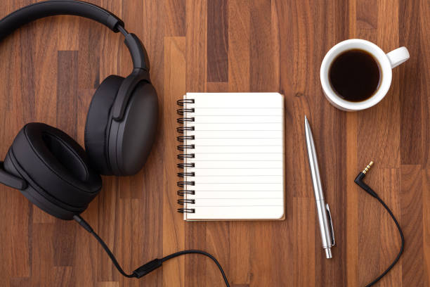 istock Notebook and pen with headphone on wood desk 1336016623