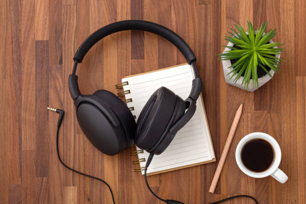 istock Headphone on notebook with coffee cup, podcast concept 1336016625