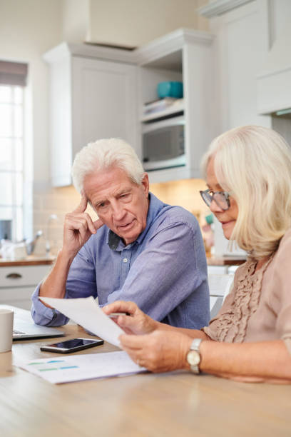 istock Shot of a senior couple looking unhappy while going through paperwork at home 1336018867