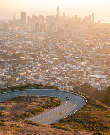 Aerial view over misty city of San Francisco, California, USA with curved road on twin peaks view point in morning.