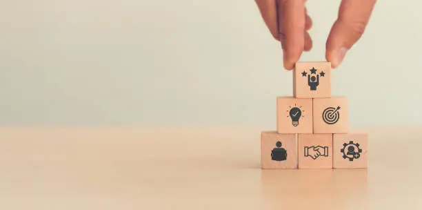 Photo of Personal development and career growth concept, hand putting wooden cubes with career promotion icon and the concept of development icon; learning, collaboration, new skills, creative and goals.