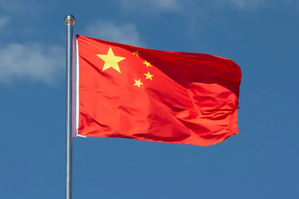 Photo of China flag waving in the wind.