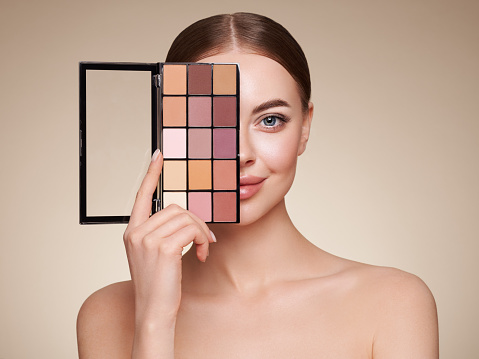 Mujer de belleza con paleta de maquillaje de sombra de ojos photo