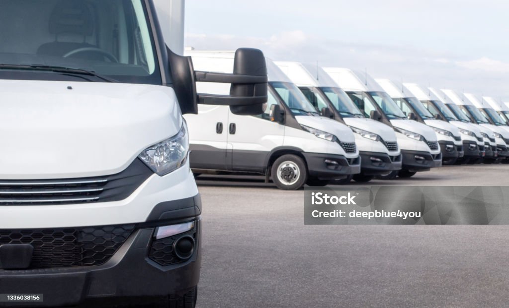 Delivery truck fleet White delivery vans in a row.  Express delivery and shipment service. Transporting service company Fleet of Vehicles Stock Photo