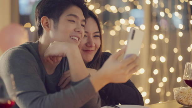 Couple dating together at restaurant making video call stock photo