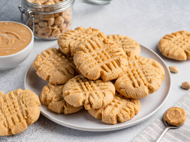 Peanut butter cookies on ceramic plate. Close-up view. Light grey concrete background. Morning breakfast or lunch. Tasty snack. Traditional american biscuits made of peanut butter. Criss cross pattern cookie. Crunchy and chewy dessert. chewy photos stock pictures, royalty-free photos & images