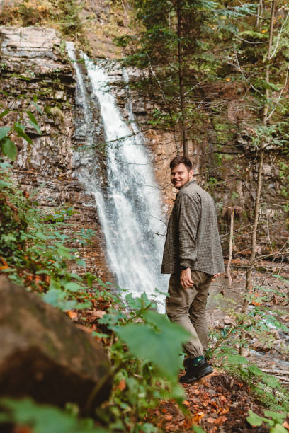 istock young strong man hiker looking the waterfall 1336041653