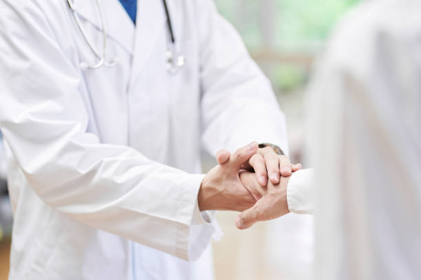 Doctor in charge of shaking hands with the patient Doctor in charge of shaking hands with the patient obscured face photos stock pictures, royalty-free photos & images