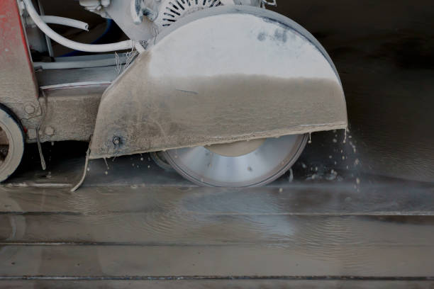 istock A machine is using blades to cut concrete slabs to make grooves in a construction parking lot. 1336043900