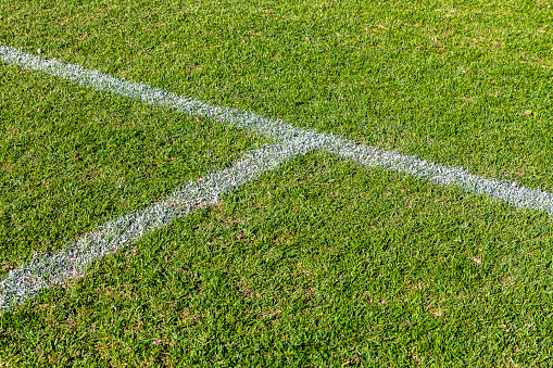 Close-up of a corner of a soccer field on an artificial turf. View from above. Detail of the football field photographed symmetrically.