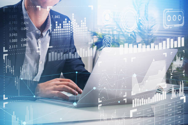 istock Businessman trader or analyst is sitting at workplace and working on laptop to develop data management in high tech company. Digital hologram interface on foreground screen. Office background. 1336046033