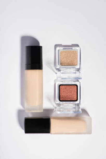 istock Above overhead view photo of two bottles with makeup foundation and open boxes with eyeshadow isolated over white backdrop 1336046165