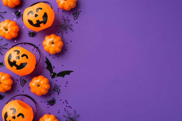 vista superior foto de halloween decoraciones cestas de calabaza negro lentejuelas tela de araña y silueta de murciélago sobre fondo violeta aislado con espacio vacío - dulces fotos fotografías e imágenes de stock
