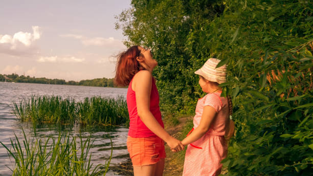 istock Two happy sisters by the river on a hot summer evening 1336047262